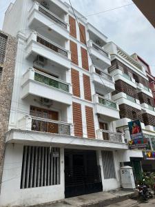 ein hohes weißes Gebäude mit Balkonen darauf in der Unterkunft Sapphire Luxury Apartment in Puducherry
