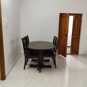 a table and chairs in a room with a door at Sapphire Luxury Apartment in Pondicherry