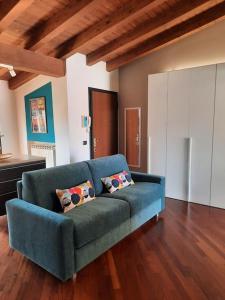 Casa Valentina - Lissone في ليسّوني: أريكة زرقاء في غرفة المعيشة مع أرضيات خشبية