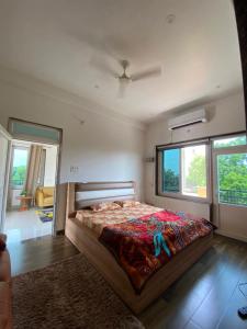 a bedroom with a bed and a large window at Kaashi Flora (Modern Suite) in Varanasi