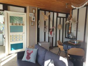 a living room with a blue couch and a table at Chalet le logis des autre in Vireux-Wallerand