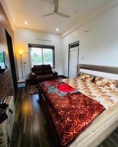 a bedroom with a large bed and a couch at Kaashi Flora (Modern Suite) in Varanasi