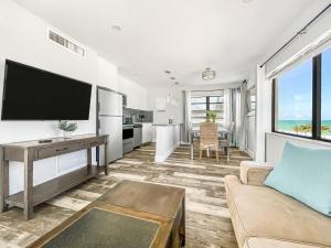 sala de estar con sofá y TV en Neptune Oceanfront Rentals, en Hollywood