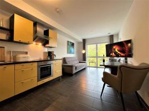 eine Küche mit einer Couch und einem Tisch in einem Zimmer in der Unterkunft Moselpromenade Villa Moselufer, Panorama & Burg Cochem Blick, Netflix, Balkon in Cochem + 9 Fotos