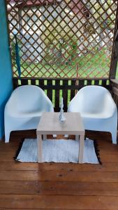 two white chairs and a table in a room at La Casuta in Fieni