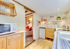 a kitchen with a sink and a microwave at Appletree Cottage in Westleton