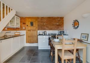 a kitchen with a wooden table and a dining room at Jasmine Cottage in Woodbridge