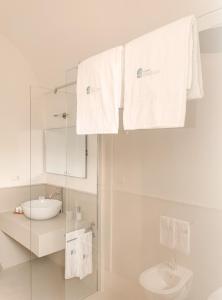 a white bathroom with a sink and a toilet at Masseria Don Luigi-Luxury Farmhouse in Savelletri di Fasano