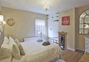 a bedroom with a large bed and a fireplace at Jasmine Cottage in Woodbridge