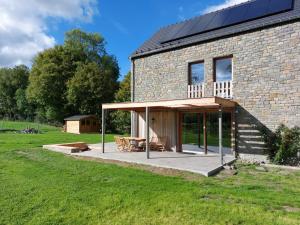 Casa de piedra con terraza y mesa en Ecologis Hamoir en Hamoir