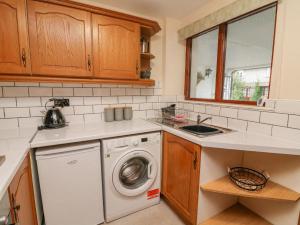 een keuken met een wasmachine en een wastafel bij No 2 The Mews in Carnforth