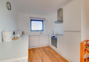 a kitchen with white cabinets and a window at Admiralty Lodge in Shotley Gate