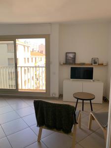 a living room with a table and a television at Joli Studio proche quartier Timone Climatisé in Marseille