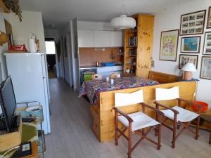 cocina con mesa, sillas y nevera en Renardière 3, en Montgenèvre