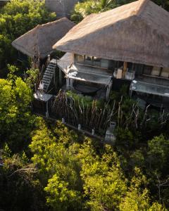 an overhead view of two buildings with grass roofs at Radhoo Tulum in Tulum