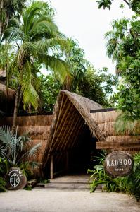 a wooden structure with a wooden fence and trees at Radhoo Tulum in Tulum
