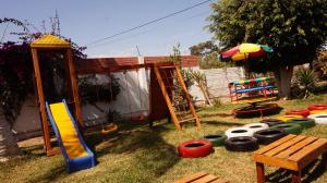 a backyard with a playground with a slide and play equipment at EL MANÁ in Huarmey