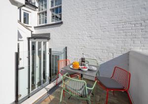 a patio with a table and chairs on a balcony at Barley Rise in Southwold