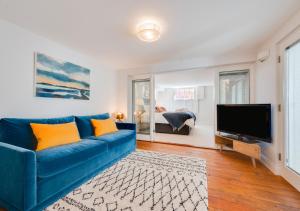 a living room with a blue couch and a flat screen tv at Barley Rise in Southwold