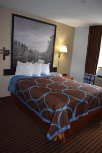 a hotel room with a large bed with a painting on the wall at Super 8 by Wyndham La Vale/Cumberland Area in La Vale