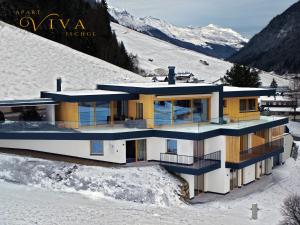 una casa en la cima de una montaña cubierta de nieve en Apart Viva Ischgl, en Ischgl