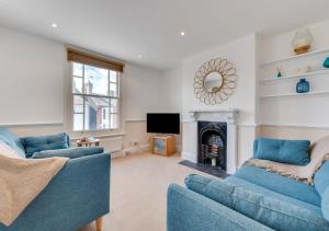 a living room with two blue couches and a fireplace at Brightseas in Southwold