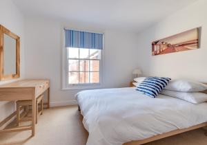 1 dormitorio con cama, escritorio y ventana en Brightseas, en Southwold