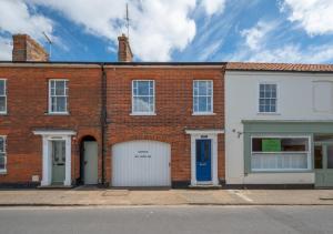 un edificio de ladrillo rojo con garaje blanco en Brightseas, en Southwold