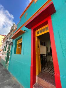 オリンダにあるCanto dos Artistas Olindaの通り沿いの黄色い扉のあるカラフルな家