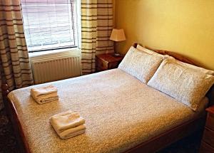 卡瑟爾的住宿－Cashel Town Center INN，一间卧室配有一张床,上面有两条毛巾