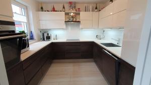 a kitchen with white counters and brown cabinets at moderne 4 Zimmer -Wohnung I BBQ I Parkplatz in Munich