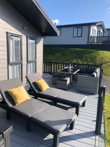 a patio with two benches and a table on a house at Mawgan Stays Mawgan Porth in Newquay