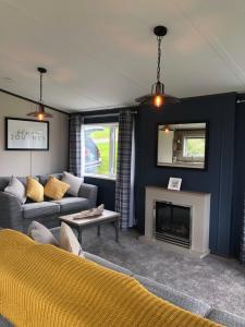 a living room with a couch and a fireplace at Mawgan Stays Mawgan Porth in Newquay