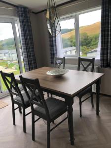 a dining room table and chairs with a large window at Mawgan Stays Mawgan Porth in Newquay