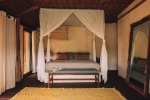 a bedroom with a bed with a canopy at Radhoo Tulum in Tulum