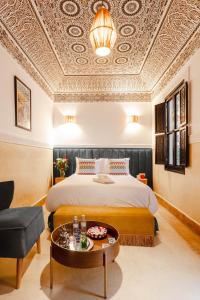 マラケシュにあるRiad JW, La Medina autrementのベッドとテーブルのあるホテルの部屋
