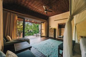 uma sala de estar com um sofá e uma ventoinha de tecto em Radhoo Tulum em Tulum