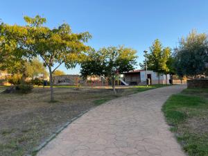 um caminho num parque com árvores e um edifício em Albergue la Fontanina em Mata de Alcántara