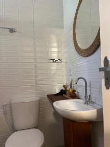 a bathroom with a toilet and a sink and a mirror at Pousada do Lago Boutique in Santarém