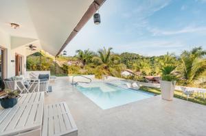 an outdoor patio with a swimming pool and a resort at Villa with 3 bedrooms private pool and ocean view in Santa Bárbara de Samaná