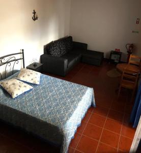 ein Wohnzimmer mit einem Bett und einem Sofa in der Unterkunft Adega do Golfinho in Feiteira