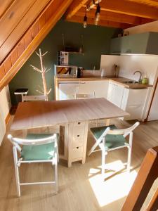 une cuisine avec une table en bois et deux chaises dans l'établissement Appartement Chalet à 1400m - Station du Mourtis, à Boutx