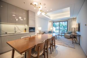 a kitchen and dining room with a large wooden table and chairs at Luxurious 3 bedroom apartment with beach and pool access in Fujairah