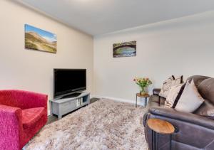 a living room with a couch and a tv at Ardley Cottage Squirrel in Waldingfield