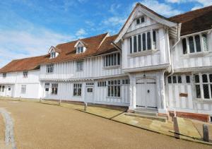 a large white building with a brown roof at Ardley Cottage Squirrel in Waldingfield