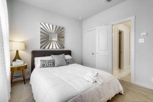 a white bedroom with a large bed and a mirror at Gorgeous 4 Bed Home on St Mary's - Minutes to Riverwalk/Pearl in San Antonio