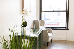 een woonkamer met een glazen tafel en een stoel bij Fashion Loft 2 bedroom Downtown in Los Angeles