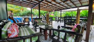 a covered patio with chairs and tables and a table at Guava Grove Resort & Villas in Sandy Bay
