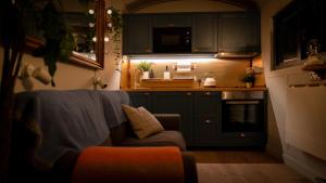 a living room with a couch and a kitchen at Cosy Double Shepherds Hut In Beautiful Wicklow With Underfloor Heating Throughout in Rathnew