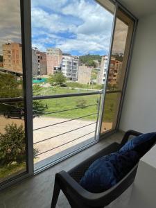 um quarto com uma cadeira e uma grande janela em Hermoso apartamento en Barbosa Santander em Barbosa
